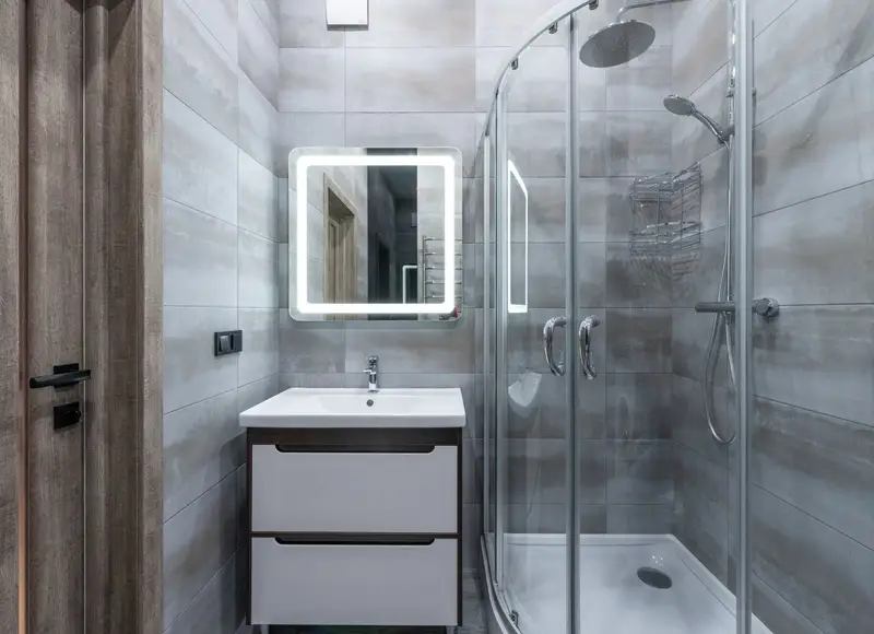 Fertiges Bad mit Walk-in-Dusche, Waschtisch und beleuchtetem Spiegel